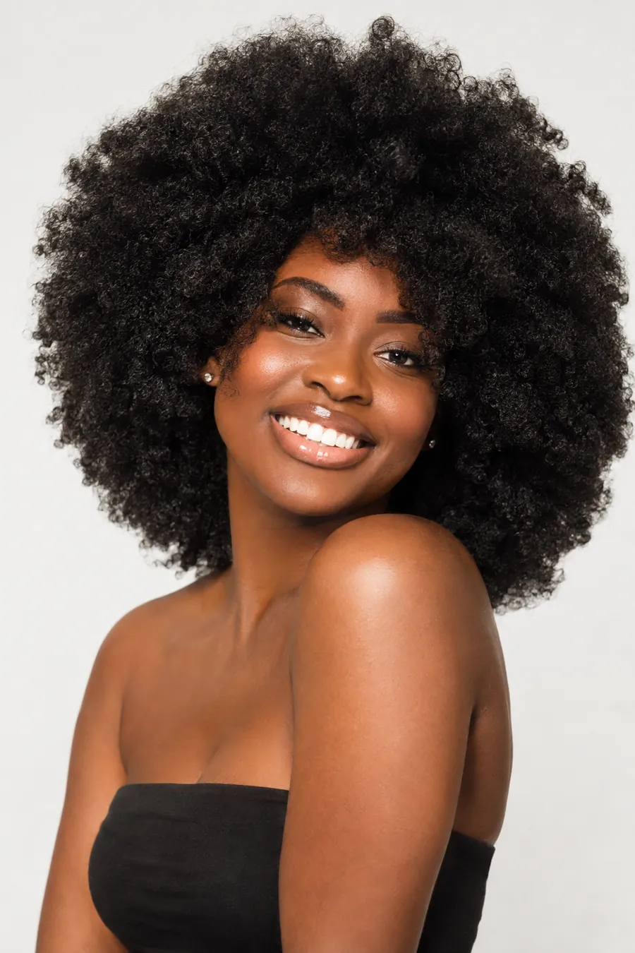 Smiling woman with a big, voluminous defined natural coily afro